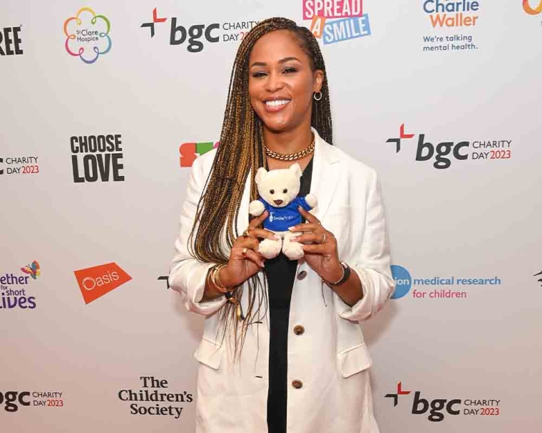 Eve smiling and holding a Smile Train teddy bear at the red carpet at BGC Charity Day
