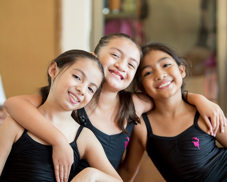 Aquetzaly smiling and hugging her ballet friends after cleft surgery