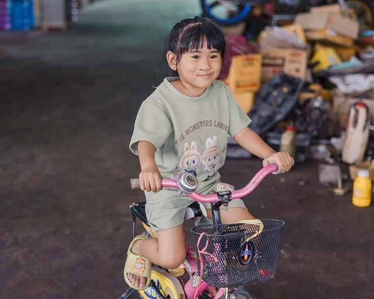 Niu smiling and riding bike after cleft surgery