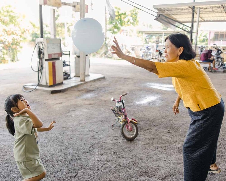 Niu and her grandmother playing with a balloon after her cleft surgery