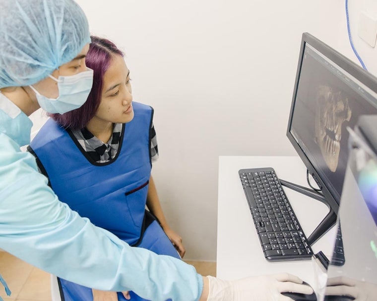 Dentist showing their cleft-affected patient their oral x-ray