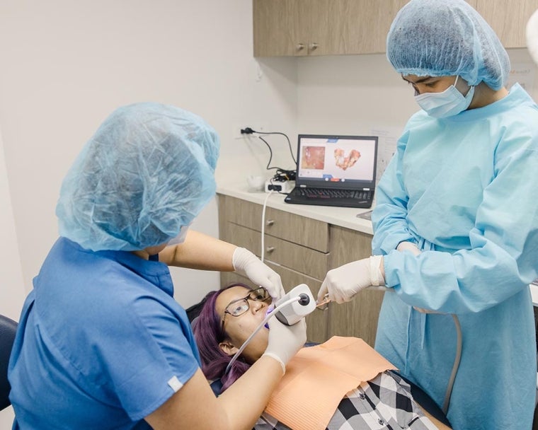 Dentists operating imaging technology on cleft-affected patient